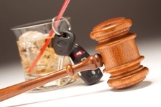 Glass of alcohol with car keys and judges gavel