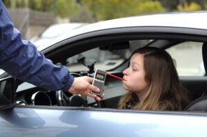A police officer oversees an intoxicated driver’s breathalyzer test