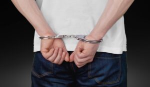 A man in handcuffs, arrested on a RICO charge