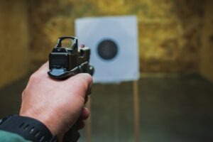 A man aiming a gun at a target at a gun range. Is owning a gun an inalienable right?